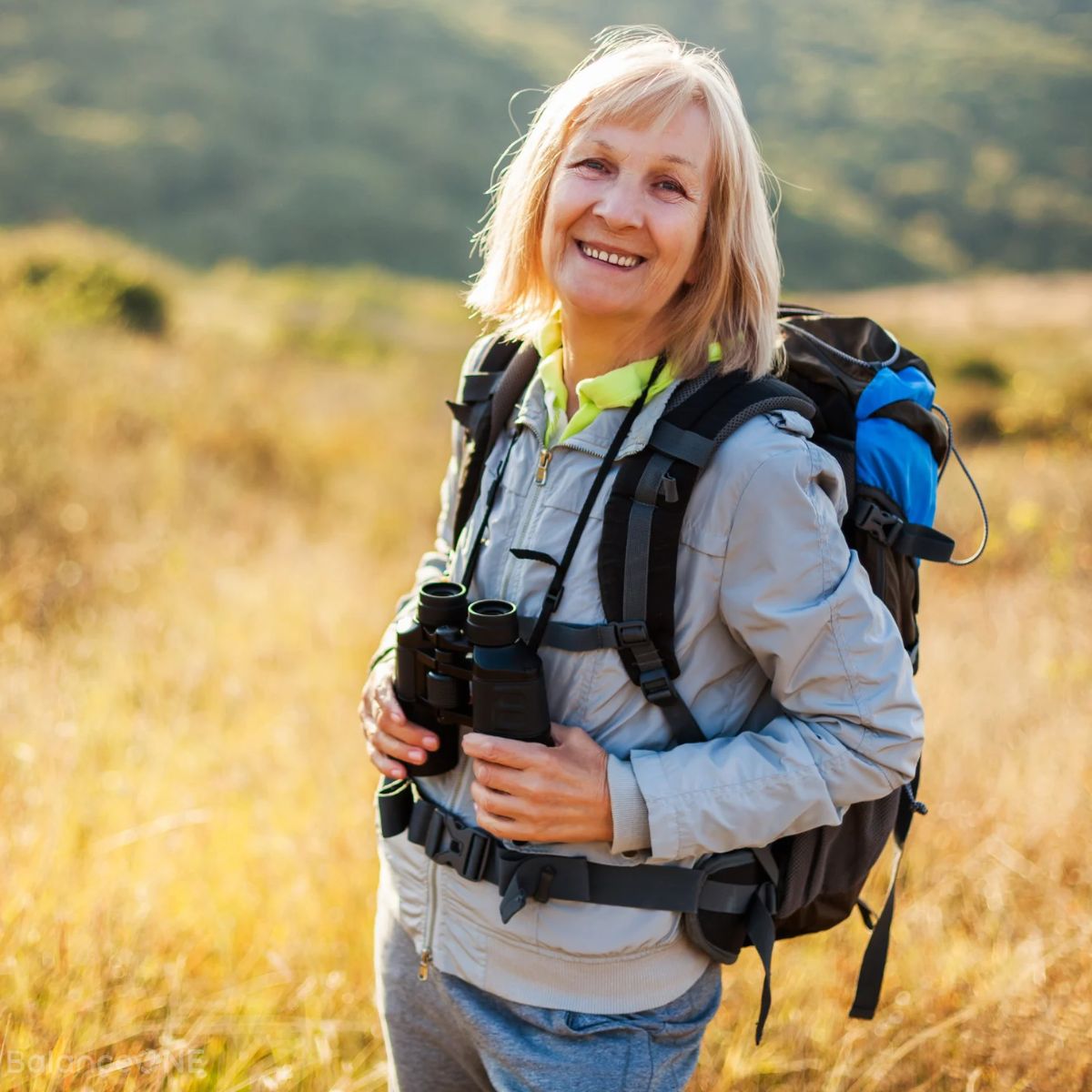 Active older woman smiling while hiking outdoors