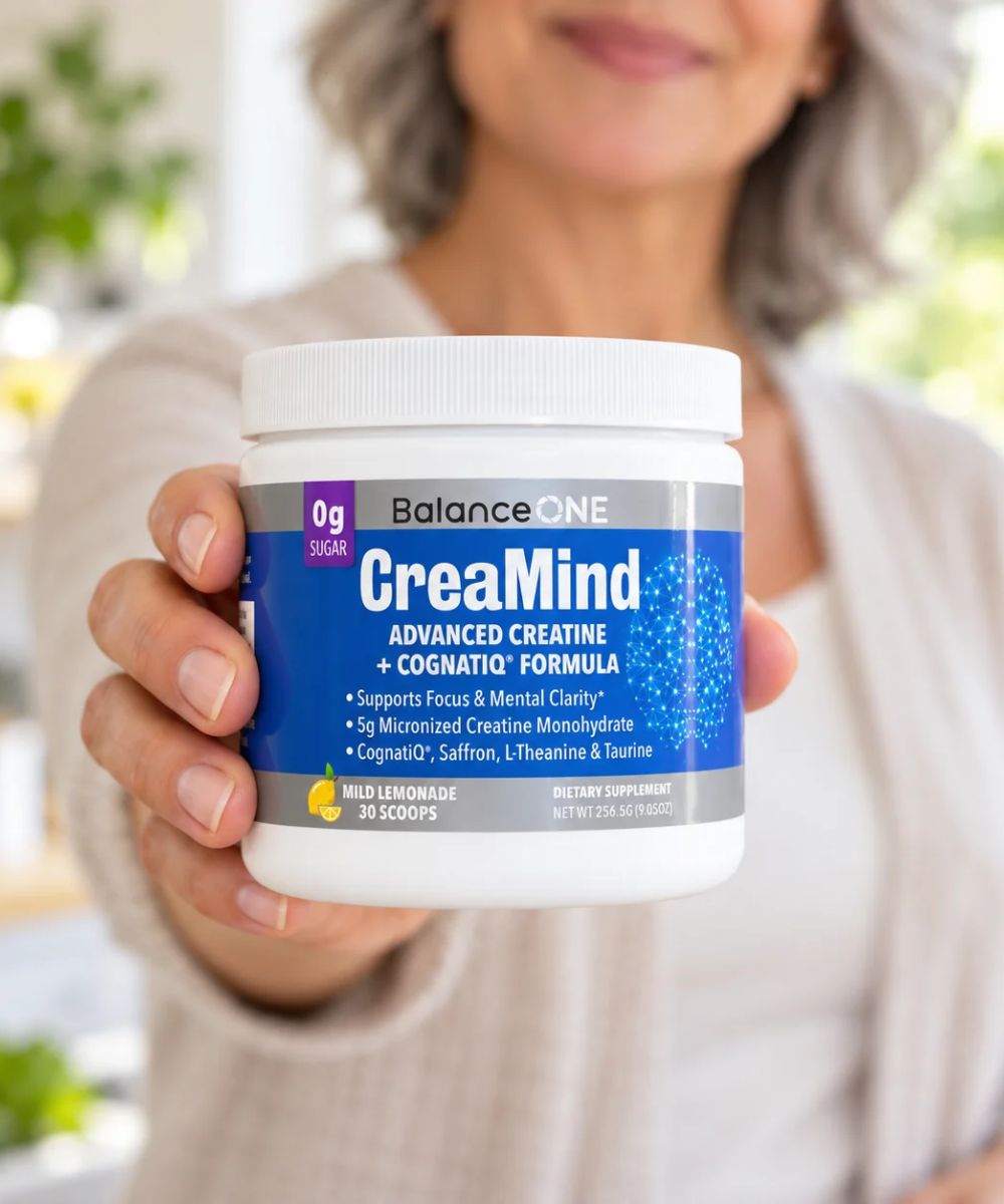 Mature woman holding a tub of Balance ONE CreaMind toward the camera