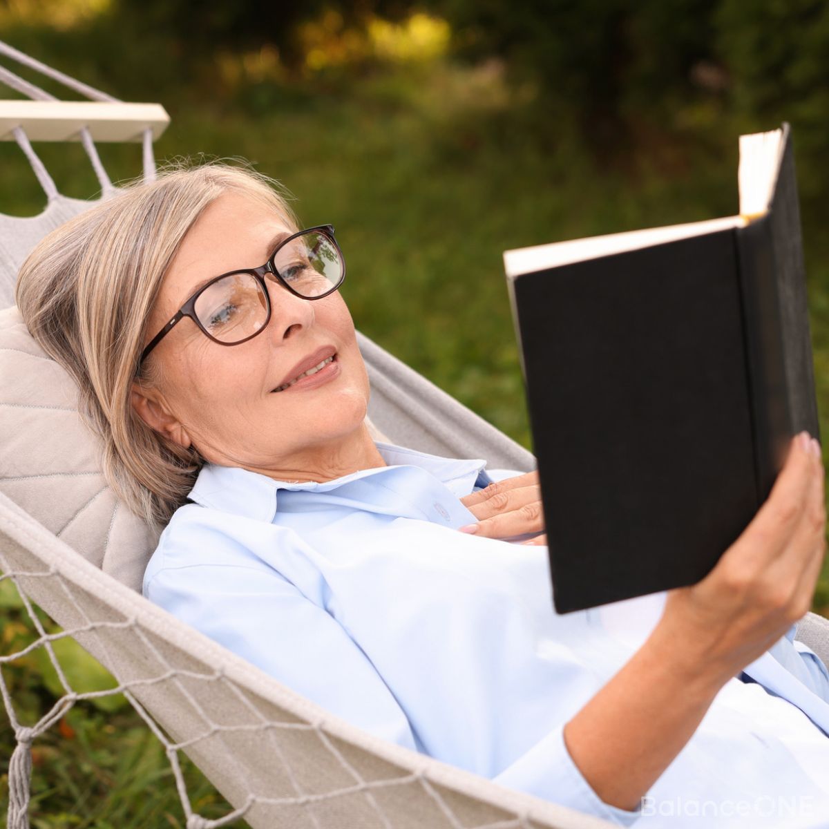 Older woman relaxing with a book outdoors
